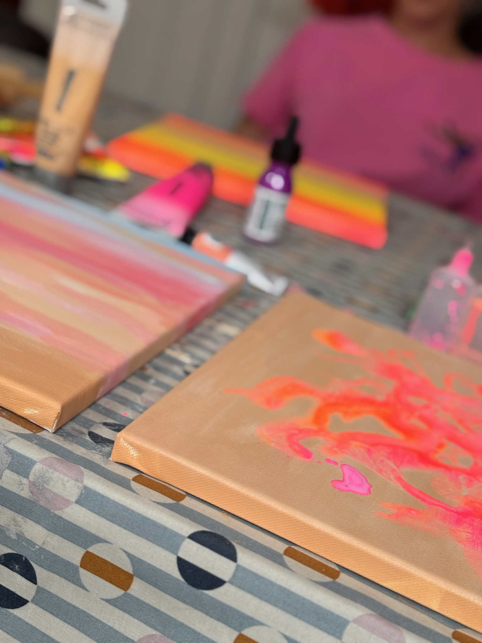 Leinwand mit leuchtenden Neonfarben und Pipetten – Beginn des intuitiven Malprozesses im Workshop.